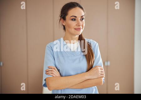 Giovane operatrice medica che posa in ufficio vuoto Foto Stock