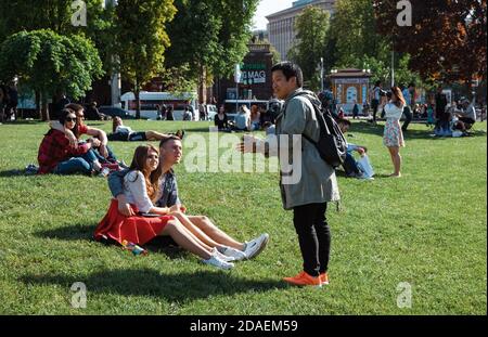 KIEV, UCRAINA - 04 maggio 2017: I giovani riposano sul prato verde in una soleggiata giornata di primavera. I cittadini si riposano sul prato dell'Independence Squar Foto Stock