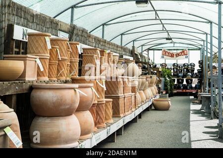 Vari stili di pentole e contenitori in terracotta resistenti al gelo in esposizione e in vendita in un giardino. Foto Stock