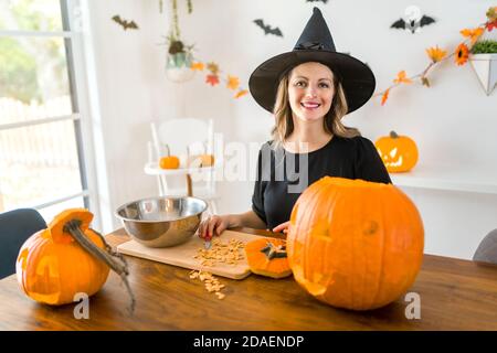 la moglie della casa ottiene un calcio fuori di intagliare la zucca Per Halloween Foto Stock