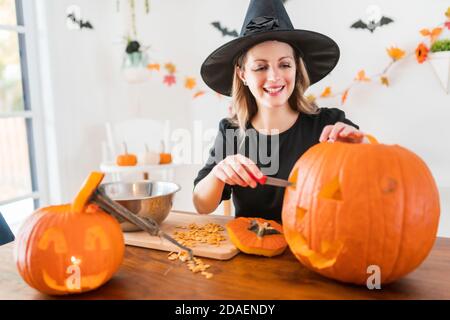 la moglie della casa ottiene un calcio fuori di intagliare la zucca Per Halloween Foto Stock