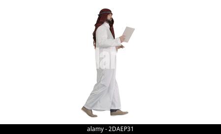 Sheikh utilizzando un tablet digitale e camminando su sfondo bianco. Foto Stock
