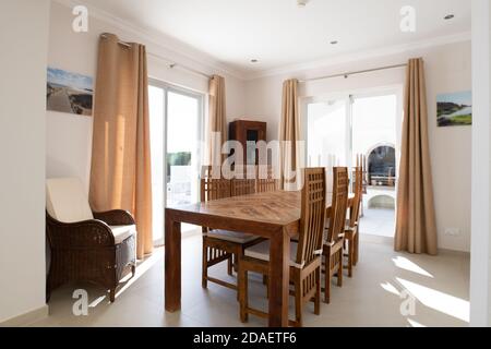 Sala da pranzo con tavolo e sedie in legno e due set di porte scorrevoli in vetro Foto Stock