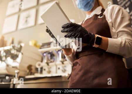 Pratico dispositivo moderno nelle mani della cameriera Foto Stock