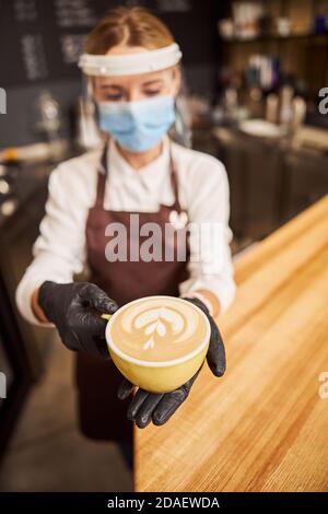 Bella tazza di caffè in mani di barista premuroso Foto Stock