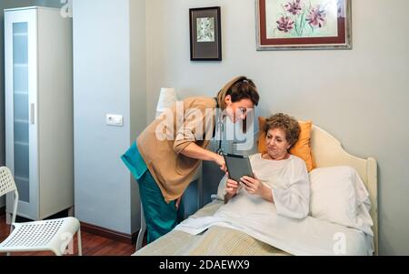 Medico femminile che mostra i risultati di un test medico su tablet Foto Stock