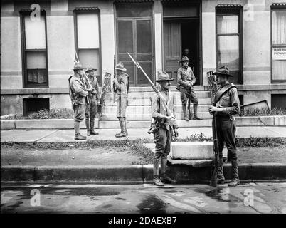 Guardia Nazionale armata che si trova fuori degli appartamenti durante le rivolte di corsa a Chicago, Illinois, 1919. Foto Stock