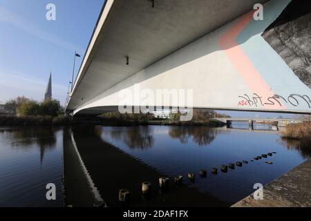 Rostock, Germania. 12 Nov 2020. La parte centrale del Ponte di Vorpommern si riflette nel Warnow, sulla sinistra la Petrikirche. Costruita nel 1983-86, la struttura, una strada di accesso principale alla città anseatica, si piega sempre più. Se i valori di deformazione degli ultimi 10 anni vengono presi come base, il ponte ha una durata utile residua di tre o sei anni. La costruzione di sostituzione deve quindi essere completata prima di quanto previsto in precedenza. Credit: Bernd Wüstneck/dpa-Zentralbild/dpa/Alamy Live News Foto Stock