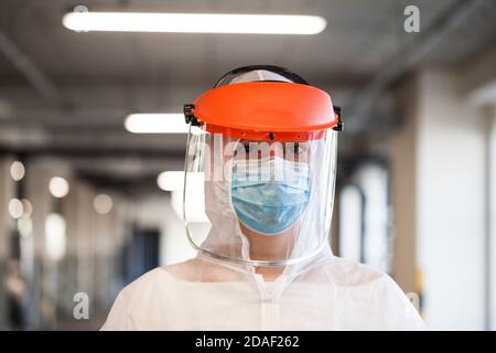 Coronavirus COVID-19 malattia del virus epidemia globale epidemia, UK NHS Frontline medico chiave lavoratore, EMS Personal Protective Equipment, parcheggio corridoio, Foto Stock