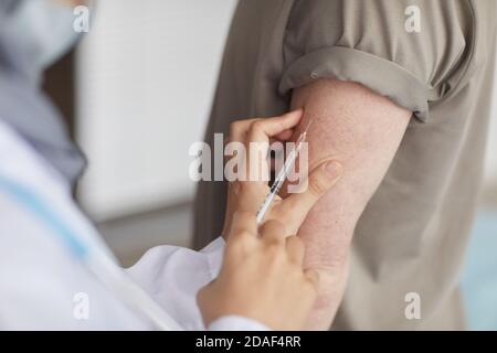 Primo piano del medico che dà un'iniezione al paziente nel suo mano Foto Stock