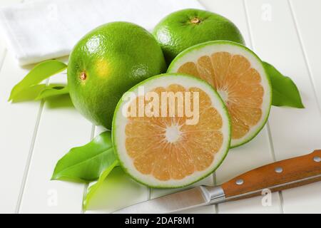 Frutti di pecora (pompelmo verde, pomeliti) - due frutti interi e fette Foto Stock