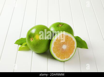 Due e mezzo frutti di amissetta (pompelmo verde, pomeliti) e foglie Foto Stock