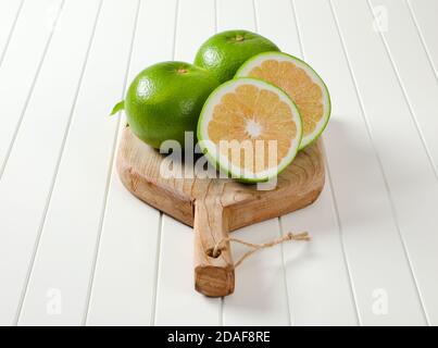 Frutti di amissina (pompelmo verde, pomeliti) sul tagliere Foto Stock