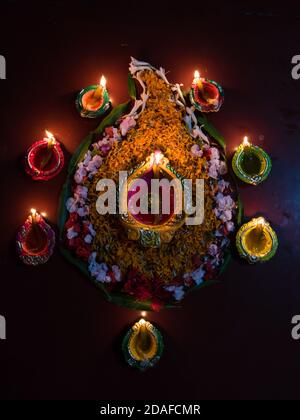 Primo piano di Diya o lampade con decorazioni floreali Per l'occasione di Diwali Foto Stock