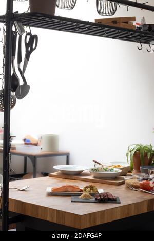 Uomo che serve spaghetti al Funghi in cucina su un tavolo di legno Foto Stock