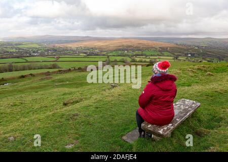 Un turista prende un momento per ammirare le viste mozzafiato del Parco nazionale di Dartmoor dalla chiesa di Burrator, Devon, Regno Unito Foto Stock
