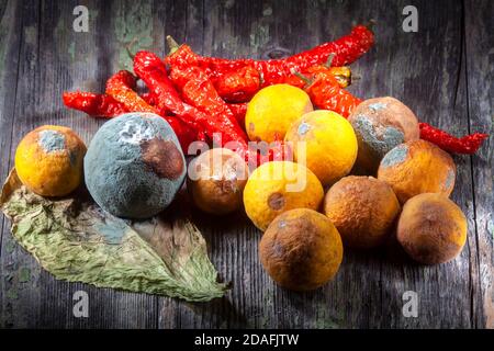 Foto di Still Life di Frittie arancioni modellate Peperoni rossi Su legno decaduto sfondo Foto Stock