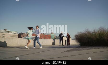 I musicisti di strada suonano, una coppia ballano, ballano il tango per strada, le persone camminano e si godono una serata calda, un musicista suona canzoni romantiche Foto Stock