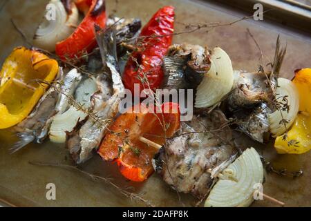 Sardine, Sardina pilchardus, che sono state acquistate da un supermercato nel Regno Unito e grigliate con peperoni, cipolle, timo fresco e olio d'oliva. Sar Foto Stock