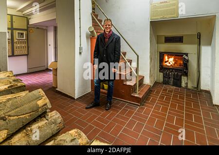 Matthias Trum, proprietario di Heller Breweryi Schlenkerla di fronte al fuoco aperto del forno di fumo a Bamberg, Germania Foto Stock