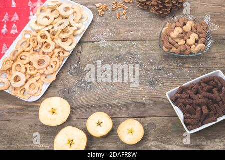 Dolci natalizi, torte e frutta secca sulla vecchia scrivania in legno. Tradizionale cottura di natale. Foto Stock