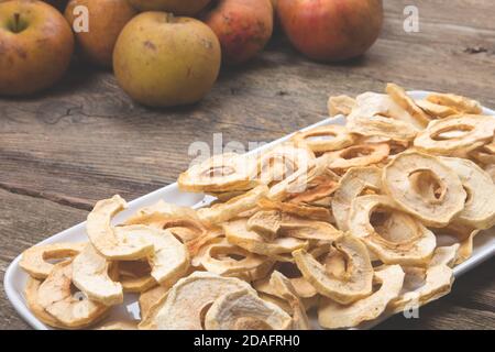 Mele secche su vecchio tavolo di legno. Frutta secca fatta in casa. Dolci tipici di natale. Foto Stock