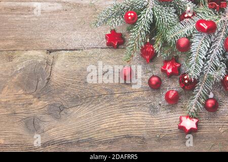 Biglietto d'auguri di Natale o valpapà in decorazione rossa con spazio per fotocopie. Sfondo in legno antico addobbato con aghi nevosi e palline rosse di natale. Foto Stock