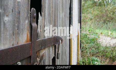 Primo piano di una serratura alla porta di un vecchio fienile marcio Foto Stock