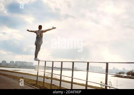 Giovane uomo che fa parkour all'aperto Foto Stock