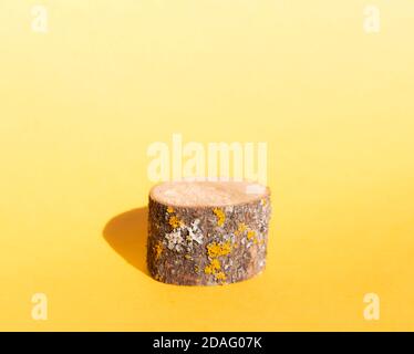 Supporto prodotto, struttura in legno naturale, forma cilindrica su sfondo giallo. Rendering 3D. Modello di layout per la pubblicità. Foto Stock