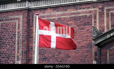 Bandiera danese con muro di mattoni a Copenhagen, Danimarca. Foto Stock