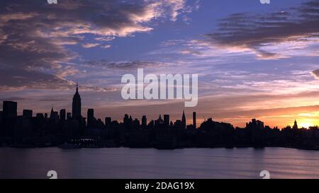 east River e New York City Manhattan, panorama di mezza città al tramonto con grattacieli. Foto Stock