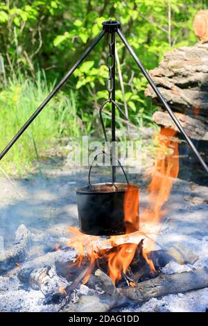 Affumicato turistico kette sopra il fuoco in foresta Foto Stock