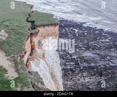 Eastbourne, East Sussex, Regno Unito. 12 Nov 2020. L'erosione naturale delle scogliere di gesso continua accelerata dal recente forte vento piovoso e alte maree. La grande fessura tra Belle Tout e Beachy Head faro, in lontananza, continua ad ampliarsi, ma il pezzo principale rimane ancora sospeso. Alta marea e gales sono previsti per Domenica. Credit: David Burr/Alamy Live News Foto Stock