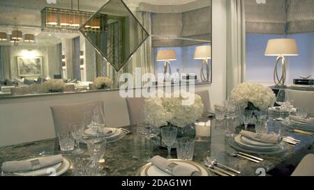 tavolo da pranzo vuoto in un lussuoso ed elegante ristorante con bicchieri, forchette e coltelli bicchieri da bibita. Foto Stock