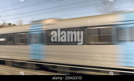 Sentiero in movimento Tram sulla ferrovia, treno ad alta velocità in movimento sulla ferrovia, con effetto di sfocatura del movimento. Sfondo a lunga esposizione Foto Stock