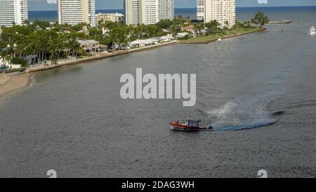 Ft. Lauderdale, FL/USA - 10/30/19: UN US Coast Guard boat accompagnatrici di una nave da crociera dentro o fuori della porta dal canale dell'oceano. Foto Stock