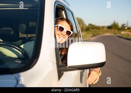 giovane bella donna sorridente che guida l'auto Foto Stock