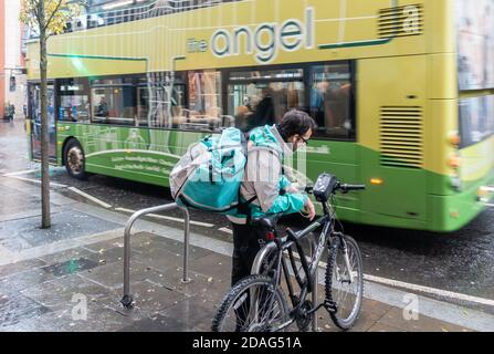 Pilota Deliveroo, corriere con moto sotto la pioggia a Newcastle upon Tyne, Inghilterra. REGNO UNITO Foto Stock