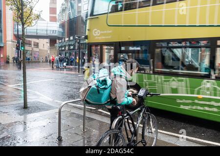 Pilota Deliveroo, corriere con moto sotto la pioggia a Newcastle upon Tyne, Inghilterra. REGNO UNITO Foto Stock