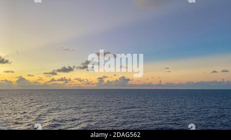 Un bellissimo tramonto rosa, blu e arancione sul mare dei caraibi in una serata frizzante. Foto Stock