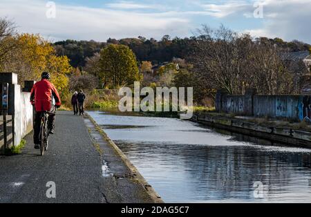 Ciclista e escursionisti sulla alzaia del canale, Union Canal, Edimburgo, Scozia, Regno Unito Foto Stock