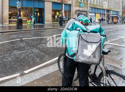 Pilota Deliveroo, corriere con moto sotto la pioggia a Newcastle upon Tyne, Inghilterra. REGNO UNITO Foto Stock