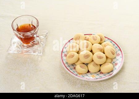 Biscotto arabo Graibe con una tazza di tè accanto esso Foto Stock