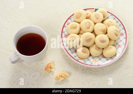 Biscotto arabo Graibe con una tazza di tè accanto esso Foto Stock