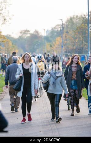 Folle di persone attraversano Tooting Common durante il secondo blocco del Regno Unito a causa del COVID-19. Foto Stock