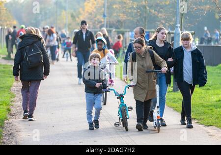 Folle di persone attraversano Tooting Common durante il secondo blocco del Regno Unito a causa del COVID-19. Foto Stock