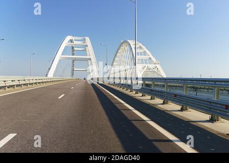 Nuova strada asfaltata sul ponte sullo stretto di Kerch. Archi bianchi di campata non supportata di strade ferroviarie e automobilistiche Foto Stock