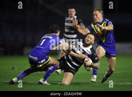 Josh Griffin (al centro) della Hull FC affrontato da Stefan Ratchford dei Warrington Wolves (a sinistra) e Jason Clark (a destra) durante la partita di play-off di Betfred Super League allo stadio Halliwell Jones di Warrington. Foto Stock