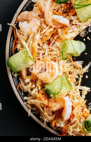 Insalata di verdure asiatiche con gamberi su sfondo nero Foto Stock